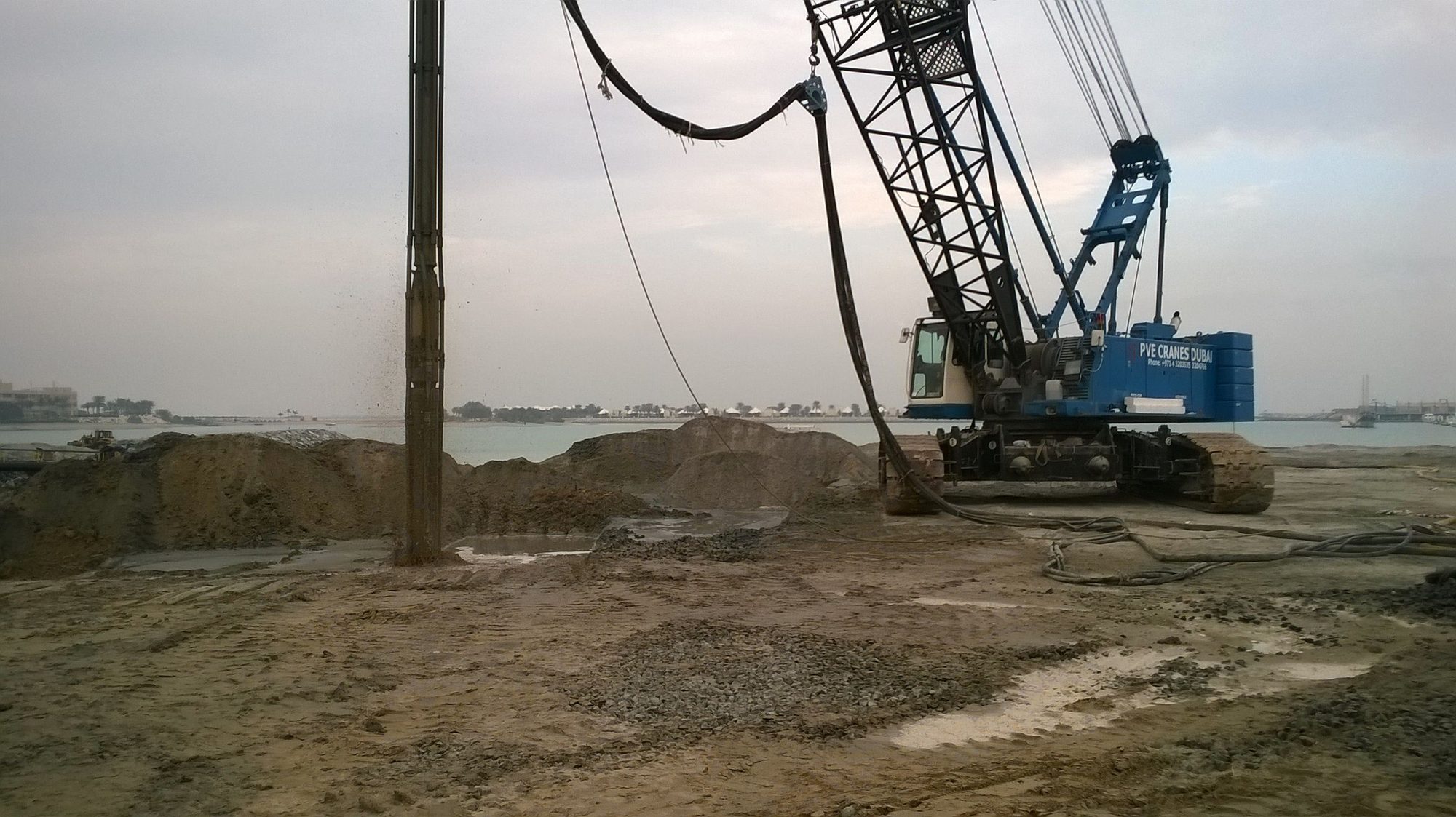 Vibro compaction rig on reclaimed land by the sea